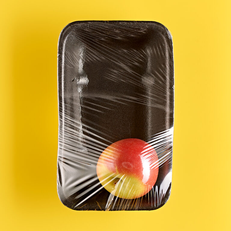 Fotografie Eduard Wellmann Apfel in Plastik-Verpackung